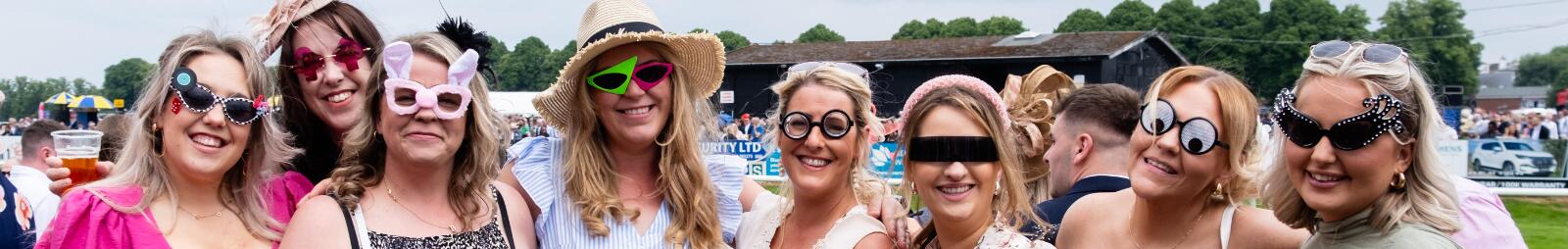 A large hen party don silly glasses for a picture at Worcester Racecourse