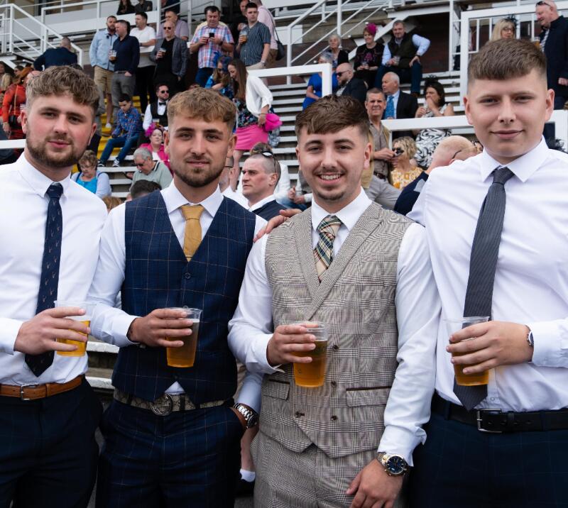A group of smartly dressed gents pose in front of the grandstand at Worcester Races